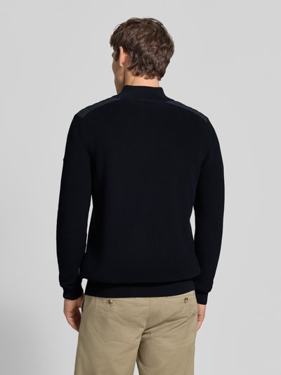 Männermodel trägt gebreide pullover met schoudervulling van puur katoen in recht model, schipperskraag, ribboorden, ruglengte maat M 68 cm, mouwlengte maat M 70 cm, Strickpullover mit gepolsterten Schultern van bugatti, Ganzkörperansicht Rückansicht.