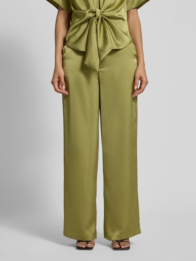 Vrouwenmodel draagt Straight Fit stoffen broek uit satijn Model 'Emmett' van Neo Noir, elastische materiaalmix, groene kleur, zijdematte textuur, achterzakken, haakjes- en ritssluiting, bandwijdte maat 36: 37 cm, binnenbeenlengte 80 cm, full body vooraanzicht