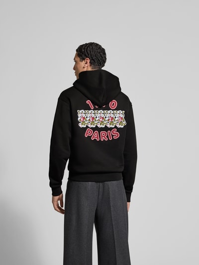 Männermodel trägt Oversized Hoodie aus reiner Baumwolle von Kenzo, schwarze Farbe, Label-Stitching, Känguru-Tasche, elastische Abschlüsse, lockere Passform, Rückenlänge 66 cm, Herren Sweatshirt, Ganzkörperansicht Rückansicht.