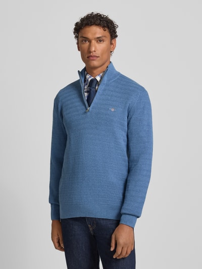 Männermodel trägt Strickpullover mit Stehkragen von Gant aus reiner Baumwolle, Regular-Fit, gerippte Abschlüsse, Label-Stitching, Ganzkörperansicht von vorne.