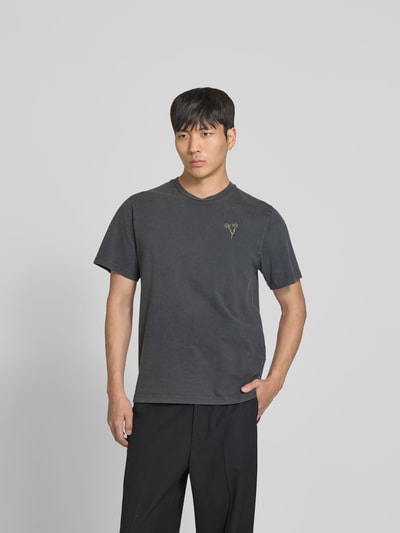 Männermodel trägt T-Shirt mit floralem Stitching von Forét aus Reine Baumwolle, Regular-Fit, Rundhalsausschnitt, Kurzärmelig, Ganzkörperansicht von vorne.