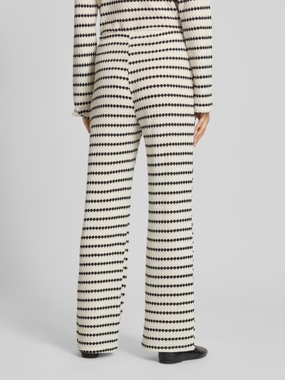 Frauenmodel trägt Loose Fit Stoffhose mit Baumwoll-Anteil Modell 'EVA LIFE' von Only, schwarz-weißes Allover-Muster, Ganzkörperansicht Rückansicht.