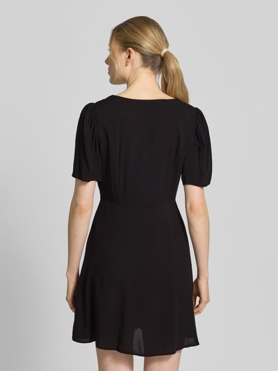 Frauenmodel trägt Leicht ausgestelltes Minikleid aus reiner Viskose Modell 'ALBA' von Vero Moda, Optik: Unifarben, Ganzkörperansicht Rückansicht.