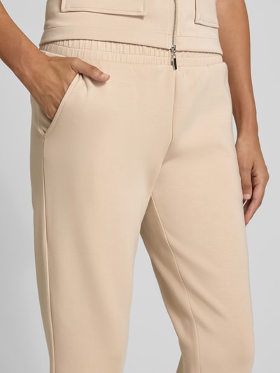 Frauenmodel trägt Cropped Sweatpants mit elastischem Bund und Eingrifftaschen von Christian Berg Woman aus Material-Mix mit Modal-Anteil, Nahaufnahme Oberkörper.