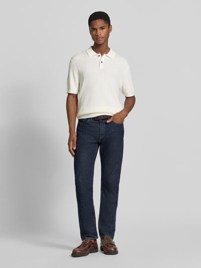 Męski model nosi Regular Fit Poloshirt mit Strukturmuster von Christian Berg Men, kołnierzyk polo, listwa guzikowa, długość tyłu 72 cm, długość rękawów 25 cm, widok całej sylwetki z przodu.