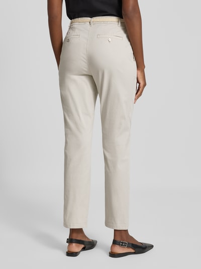 Frauenmodel trägt Chino mit Gürtel und Gesäßtaschen von Christian Berg Woman, Baumwoll-Elasthan-Mix, Regular Fit, Ganzkörperansicht Rückansicht.