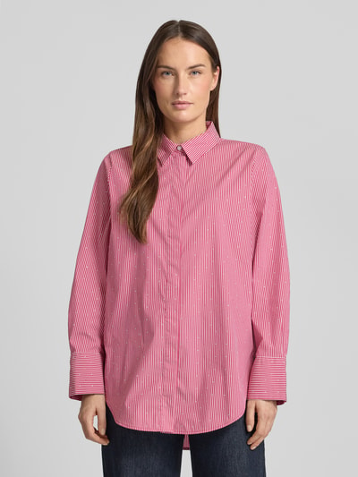 Vrouwenmodel draagt Relaxed Fit Hemdbluse aus Baumwoll-Mix van Tom Tailor met roze-wit streepmotief en strass, voorkant volledig zichtbaar, Ganzkörperansicht von vorne.