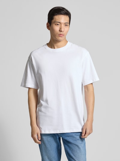 Männermodel trägt Relaxed Fit T-Shirt aus Bio-Baumwoll-Mix Modell 'MAARKOS' von Armedangels in Weiß, unifarben, Jerseystruktur, Ganzkörperansicht von vorne.