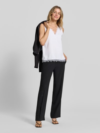 Frauenmodel trägt Regular Fit Bluse mit Spitzenbesatz Modell 'Bicco' von FREE/QUENT im weißen Elastischer-Material-Mix, Ärmelloses-Design, V-Ausschnitt, Rückenlänge 44 cm, Ganzkörperansicht von vorne.