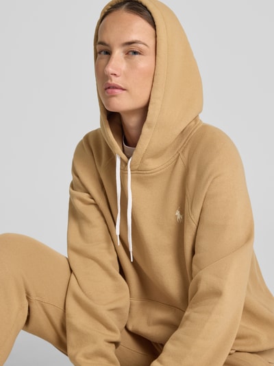 Vrouwenmodel draagt Comfort Fit Hoodie uit katoenmix van Polo Ralph Lauren in lichtbruin, zachte structuur, Nahaufnahme bovenlichaam.