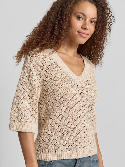 Kobiece model nosi Boxy Fit Strickpullover aus Baumwoll-Mix Modell 'AMBER' od Pepe Jeans w kolorze beżowym, ażurowa faktura z aplikacją z metką, wykończenie prążkowane, mieszanka bawełny, imitacja dzianiny, krótki rękaw, dekolt w serek, widok całej sylwetki z przodu