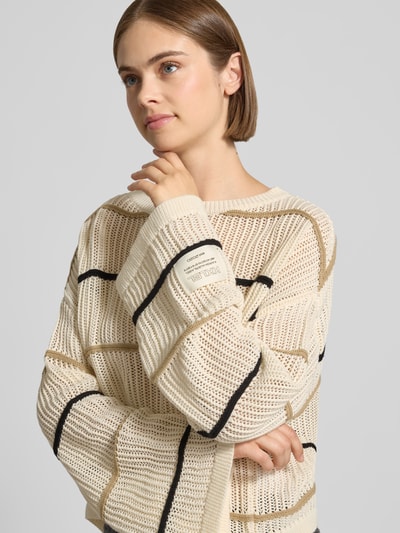 Frauenmodel trägt Oversized Strickpullover mit Label-Detail und Rundhalsausschnitt von Karo Kauer, Grobstrick, creme mit schwarzen Streifen, Nahaufnahme Oberkörper.