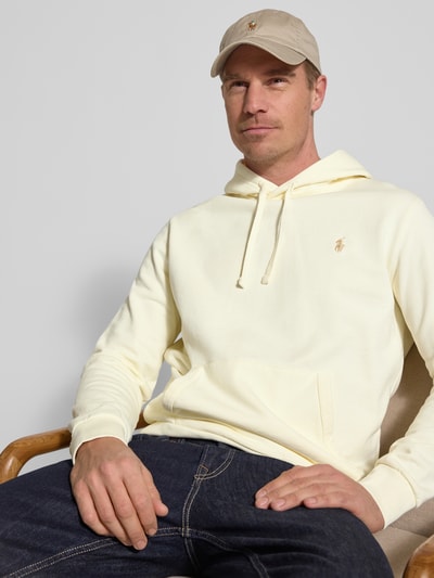 Männermodel trägt Relaxed Fit Hoodie aus reiner Baumwolle von Polo Ralph Lauren, effen kleuren, logodetail, kangoeroezak, capuchon met tunnelkoord, lange mouwen, mouwboord en rompzoom geribd, sweatmateriaal, puur katoen. Nahaufnahme Oberkörper.