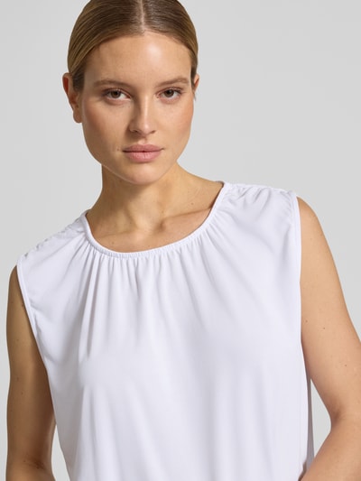 Frauenmodel trägt Loose Fit Blusentop aus Modal-Mix Modell 'FILLI' von Vero Moda, Optik: Unifarben, Rundhals-Ausschnitt, Ärmelform: Ohne, Materialverarbeitung: Stretch, weiße glatte Oberfläche, Nahaufnahme Oberkörper.