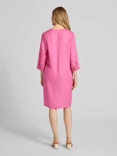 Frauenmodel trägt Knielanges Tunikakleid aus Lyocell von Lanius in Pink, gerader Schnitt, V-Ausschnitt, 3/4-Arm, glatte Textur, Ganzkörperansicht Rückansicht.