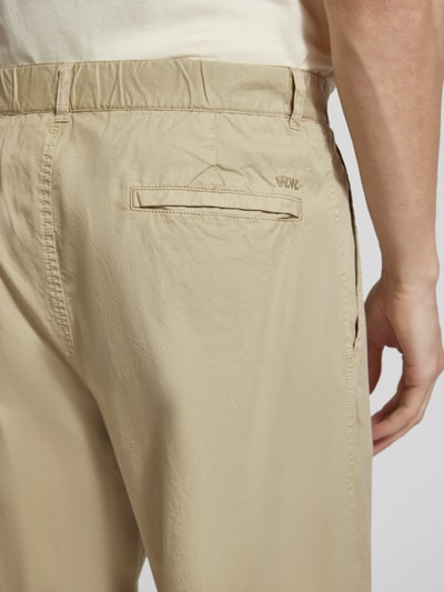 Männermodel trägt Hose mit französischen steekzakken Modell 'Ethan' van Wood Wood van puur katoen in beige, detailaufnahme achterkant.