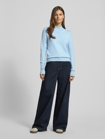 Kobiece modelka nosi Sweter z dzianiny z stójką marki Christian Berg Woman, mieszanka wiskozy, luźny krój, prążkowane wykończenia, długość tyłu 62 cm, długość rękawów 66 cm, jasnoniebieski, krótki zamek błyskawiczny, cała sylwetka z przodu.