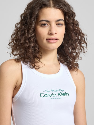 Kobiece modelka nosi Top mit Label-Stitching Modell 'CONTOUR' von Calvin Klein Jeans z mieszanka bawełny, dopasowany krój, dekolt w łódkę, wyhaftowane logo; zbliżenie na górną część ciała.