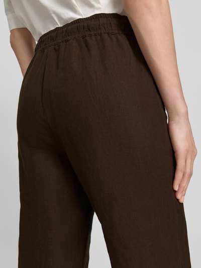 Männermodel trägt Regular Fit Weite Hose aus reinem Leinen Modell 'FARINA' von Brax, ciemnobrązowy, gładki materiał, z elastycznym ściągaczem w talii, kieszenie z wejściem, krój regular fit, materiał: czysty len. Nahaufnahme tyłu.