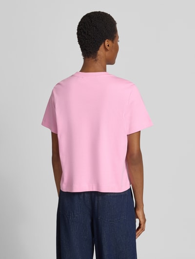 Vrouwenmodel draagt Boxy fit t-shirt van zuiver katoen model 'SARA' van VERO MODA in lichtroze, effen oppervlak, achterkant volledige lichaamsweergave.