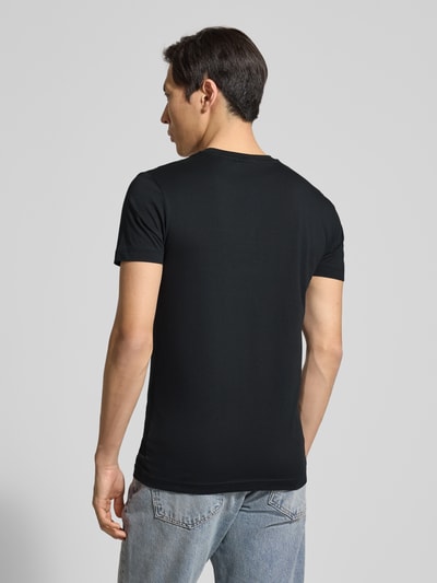 Männermodel trägt T-Shirt mit Label-Detail van Gant in zwart, recht model, puur katoen, ronde hals, ruglengte bij maat M 70 cm, Ganzkörperansicht Rückansicht.