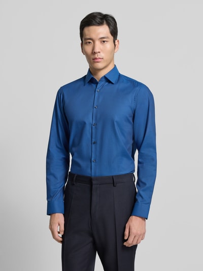 Männermodel trägt Regular Fit Business Hemd aus Baumwolle mit Kentkragen von Jake*s in Blau, glatte Textur, Ganzkörperansicht von vorne. Rückenlänge 70 cm, Schulterbreite 47 cm, Ärmellänge 64 cm.