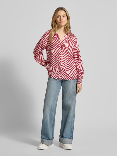 Vrouwenmodel draagt Hemdbluse mit Knopfleiste Modell 'BECCA' van Soyaconcept, los vallend, viscosemix, V-hals, rood-wit grafisch patroon, vooraanzicht volledig lichaam.