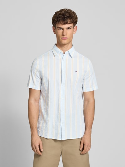 Männermodel trägt Regular Fit Freizeithemd aus Baumwoll-Mix von Tommy Jeans mit Optik:Allover-Muster, gestreift, Ganzkörperansicht von vorne.