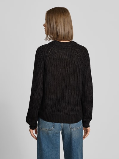Frauenmodel trägt Relaxed Fit Cardigan in Strick-Optik Modell 'CHARLIE' von NOISY MAY®, schwarze Farbe, strukturierte Oberfläche, Ganzkörperansicht Rückansicht.