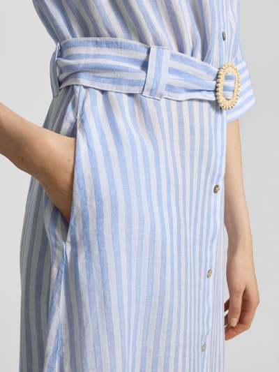 Vrouwenmodel draagt Hemdblusenkleid aus Leinen mit Gürtel van Christian Berg Woman, lichtblau-wit gestreept, linnen, taillering, knopen, riem, midi, blousekraag, detailopname zijkant.
