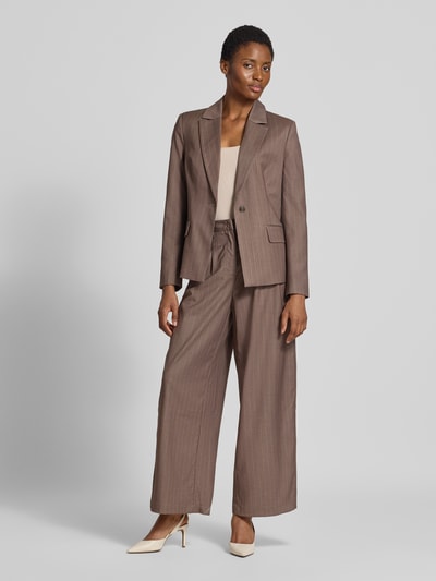 Frauenmodel trägt Wide Fit Hose mit Viskose-Anteil Modell 'Fee' von GUIDO MARIA KRETSCHMER WOMAN, braun, strukturierte Oberfläche, Bundfalten, Gesäßtasche, elastischer Material-Mix, Ganzkörperansicht von vorne.