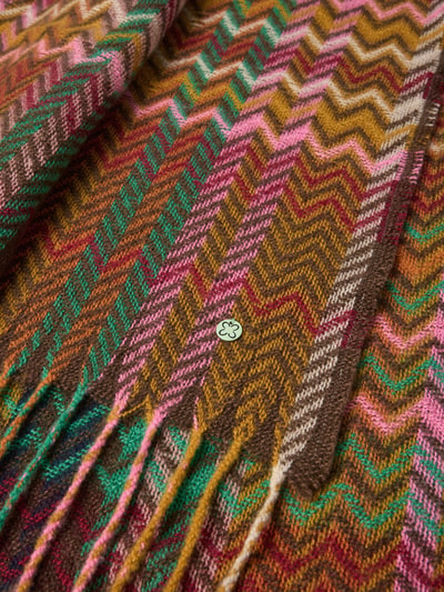 Produktfoto, Schal mit Fransen und Allover-Print von Codello, buntes Zickzackmuster in Braun, Pink, Grün und Gelb, Label-Detail sichtbar, Breite 54 cm, Länge 96 cm