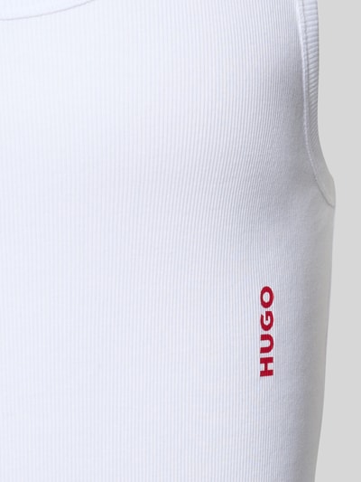 Männermodel trägt weißes, fein geripptes Shaped Fit Unterhemd aus Baumwolle, Label-Schriftzug, Nahaufnahme Oberkörper, Tank Top Tripl von HUGO.