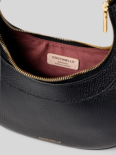 Produktfoto, schwarze Shoulder Bag mit Strukturmuster Modell 'Whisper' von Coccinelle, Reißverschluss, goldene Details, Nahaufnahme Innenansicht, Hauptfach mit Futter, Kontext: Damen Shoulder Bag, italienisches Leder, verstellbarer Schulterriemen, Größe 24x24x6 cm, Schulterriemenlänge 58 cm.