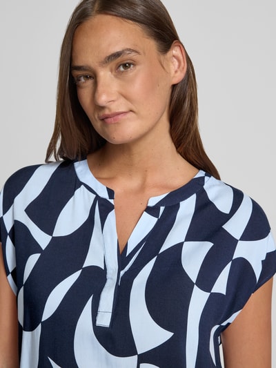 Frauenmodel trägt Regular Fit Bluse aus Viskose mit V-Ausschnitt Modell 'CHANISE' von Soyaconcept im Allover-Look mit abstraktem Muster, Nahaufnahme Oberkörper.