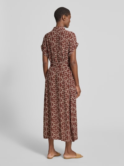 Frauenmodel trägt Midikleid aus Viskose mit Bindegürtel von Gant, braunes geometrisches Muster, Taillierter Schnitt, Ganzkörperansicht Rückansicht. Rückenlänge ca. 130 cm, Brustweite ca. 53 cm, Ärmellänge ca. 10 cm, Hemdblusenkragen, verdeckte Knopfleiste.