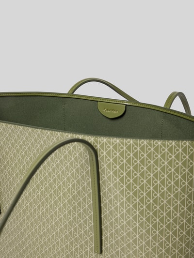 Produktfoto, Shopper mit Logo-Muster von Calvin Klein in Grün mit Tragehenkel, geometrische Textur, herausnehmbare Pouch-Tasche erkennbar