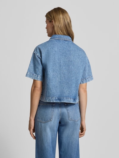 Frauenmodel trägt Loose Fit Jeansbluse aus reiner Baumwolle Modell 'SKY' von Pieces in Denim-Optik, überschnittene Schultern, Ganzkörperansicht Rückansicht.