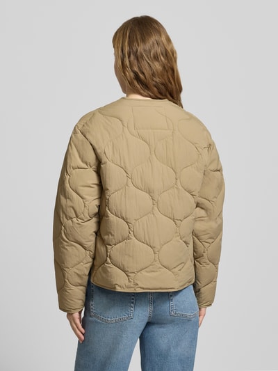 Frauenmodel trägt Steppjacke mit Knopfleiste Modell 'HOPE' von JJXX in Beige, wattierte Struktur, leicht glänzende Oberfläche, Ganzkörperansicht Rückansicht. Gerade Passform, Rundhalsausschnitt, Pattentaschen, Rückenlänge 56 cm, Schulterbreite 45 cm, Brustweite 51 cm, Ärmellänge 56 cm.