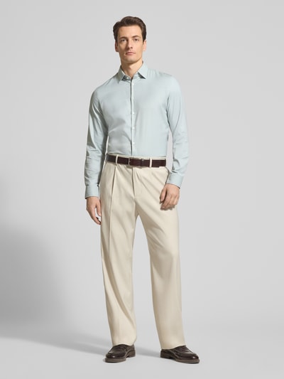 Männermodel trägt Slim Fit Business-Hemd mit Kentkragen von Jake*s in hellblau, Material-Mix mit Stretch-Anteil, Knopfleiste, Ganzkörperansicht von vorne.