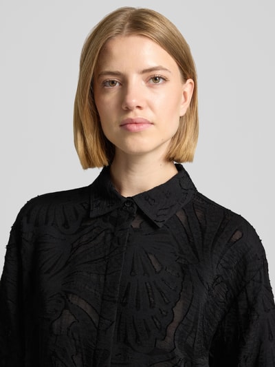 Frauenmodel trägt Regular Fit Bluse aus Viskose-Mix Modell 'Zlowera' von someday, Allover-Look in Schwarz, Nahaufnahme Oberkörper.