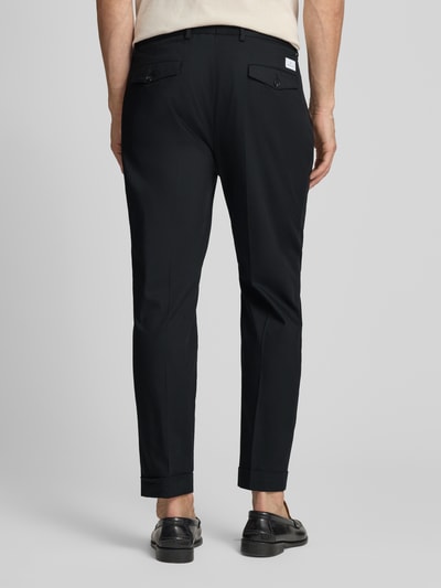 Männermodel trägt Hose mit gelegten Falten und Eingrifftaschen von Manuel Ritz aus schwarzem Baumwoll-Mix mit Stretch-Anteil, Regular-Fit, Pattentaschen am Gesäß, Label-Detail, Bundweite bei Größe 50: 50 cm, Innenbeinlänge bei Größe 50: 72 cm, Ganzkörperansicht Rückansicht.