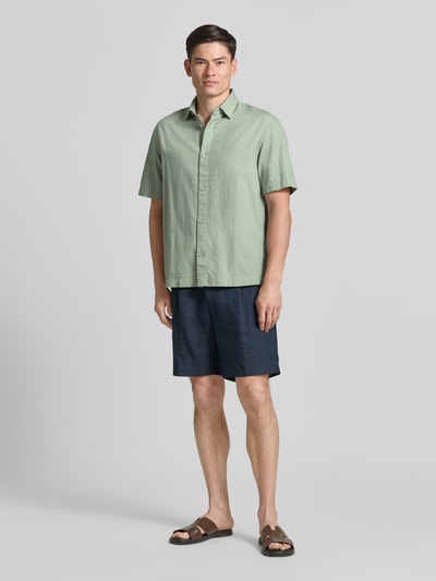 Männermodel trägt Loose Fit Freizeithemd aus reiner Baumwolle von Tom Tailor Denim, Optik: Unifarben, Passform: Loose-Fit, Kentkragen, einreihige Knopfleiste, Kurzarm, Material: reine Baumwolle, Ganzkörperansicht von vorne.