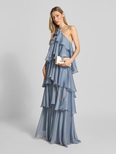 Frauenmodel trägt Clutch aus Satin mit Knotendetail von Jake*s Cocktail, silberfarben, mit Überschlag, Magnetverschluss, Schulterriemen, Ganzkörperansicht von vorne.