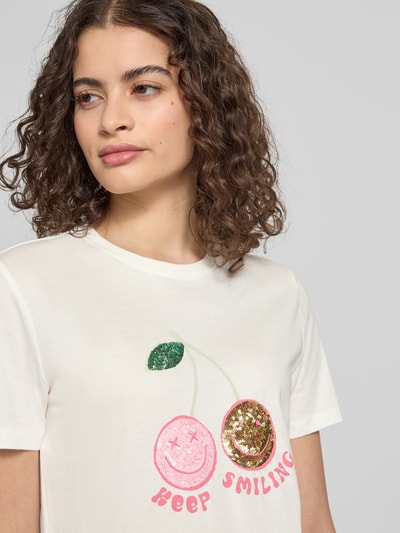 Frauenmodel trägt Regular Fit T-Shirt aus reiner Baumwolle Modell 'KITA' von Only, Optik: Unifarben, Motiv-Print mit Paillettenbesatz, Rundhals, Kurzarm, Materialverarbeitung: Jersey, Nahaufnahme Oberkörper.