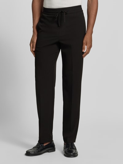 Männermodel trägt Relaxed Fit Sweatpants mit Viskose-Anteil von Lindbergh in Schwarz, Elastischer-Material-Mix, Bügelfalten, Nahaufnahme Oberkörper. Bundweite 41 cm, Innenbeinlänge 79 cm, Größe M, elastischer Bund mit Tunnelzug.