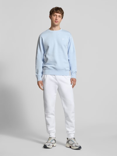 Männermodel trägt Sweatpants mit Label-Stitching und Gesäßtasche von Nike in Weiß, Baumwoll-Mix, Regular-Fit, Ganzkörperansicht von vorne.