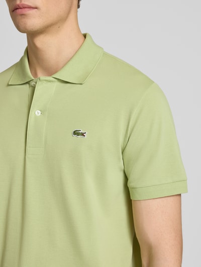Männermodel trägt Regular Fit Poloshirt aus Baumwoll-Mix von Lacoste, Optik: Unifarben, Logo-Detail, Nahaufnahme Oberkörper.