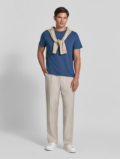 Männermodel trägt Regular Fit T-Shirt aus reiner Baumwolle von Tom Tailor in Blau zu heller Hose, neutraler Hintergrund, Ganzkörperansicht von vorne. Herren T-Shirt von Tom Tailor.