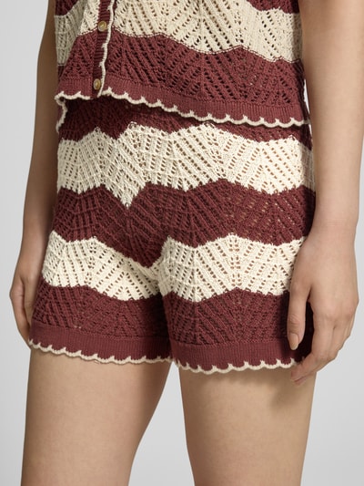 Frauenmodel trägt Regular Fit Shorts aus reiner Baumwolle Modell 'GOLDEN COVE' von Vero Moda mit gestreifter Strickoptik, Nahaufnahme Oberschenkel.